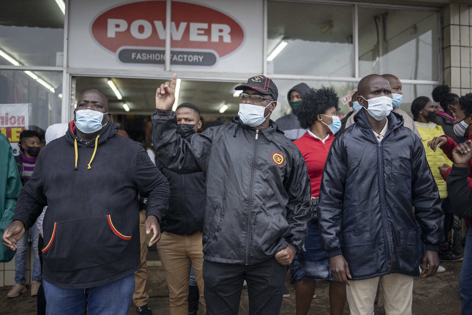 People staging outside a factory in masks protesting
