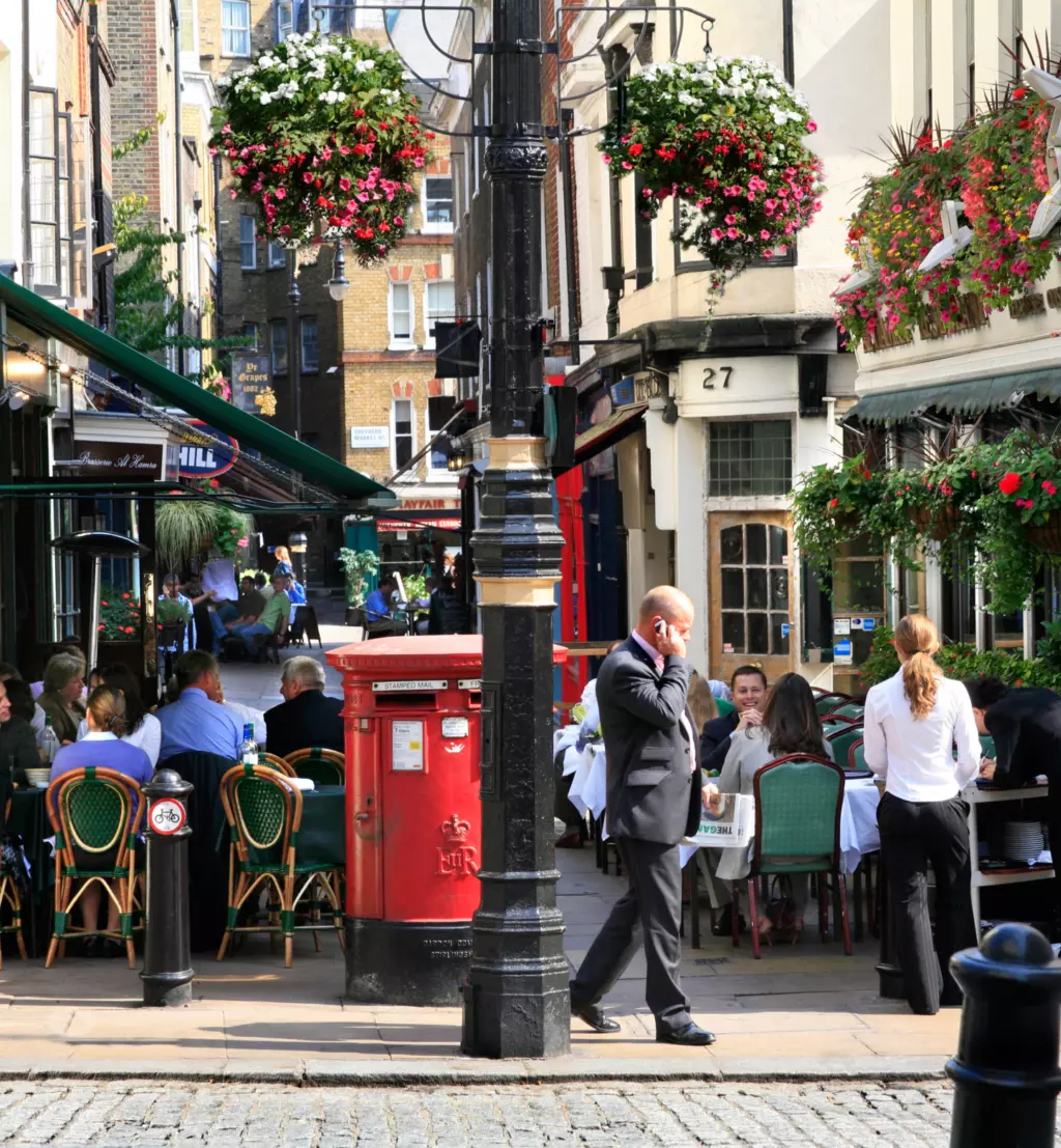 A street view in Mayfair with café and bunting overhead.
